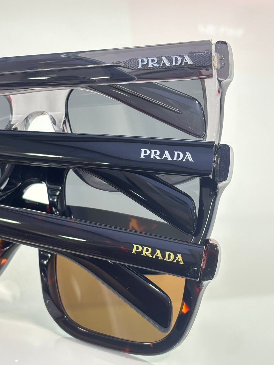 Prada glasses, layered side view with navy frames and amber lenses