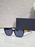 Dior sunglasses with black frames, blue tinted lenses, and gold logo hinge detail