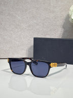 Dior sunglasses with black frames, blue tinted lenses, and gold logo hinge detail