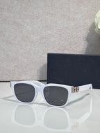 Dior sunglasses with white frames, dark tinted lenses, and gold logo hinge detail