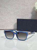 Dior sunglasses with blue frames, light tinted lenses, and gold logo hinge detail