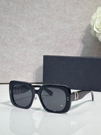 Black square sunglasses with dark lenses and gold logo hinge