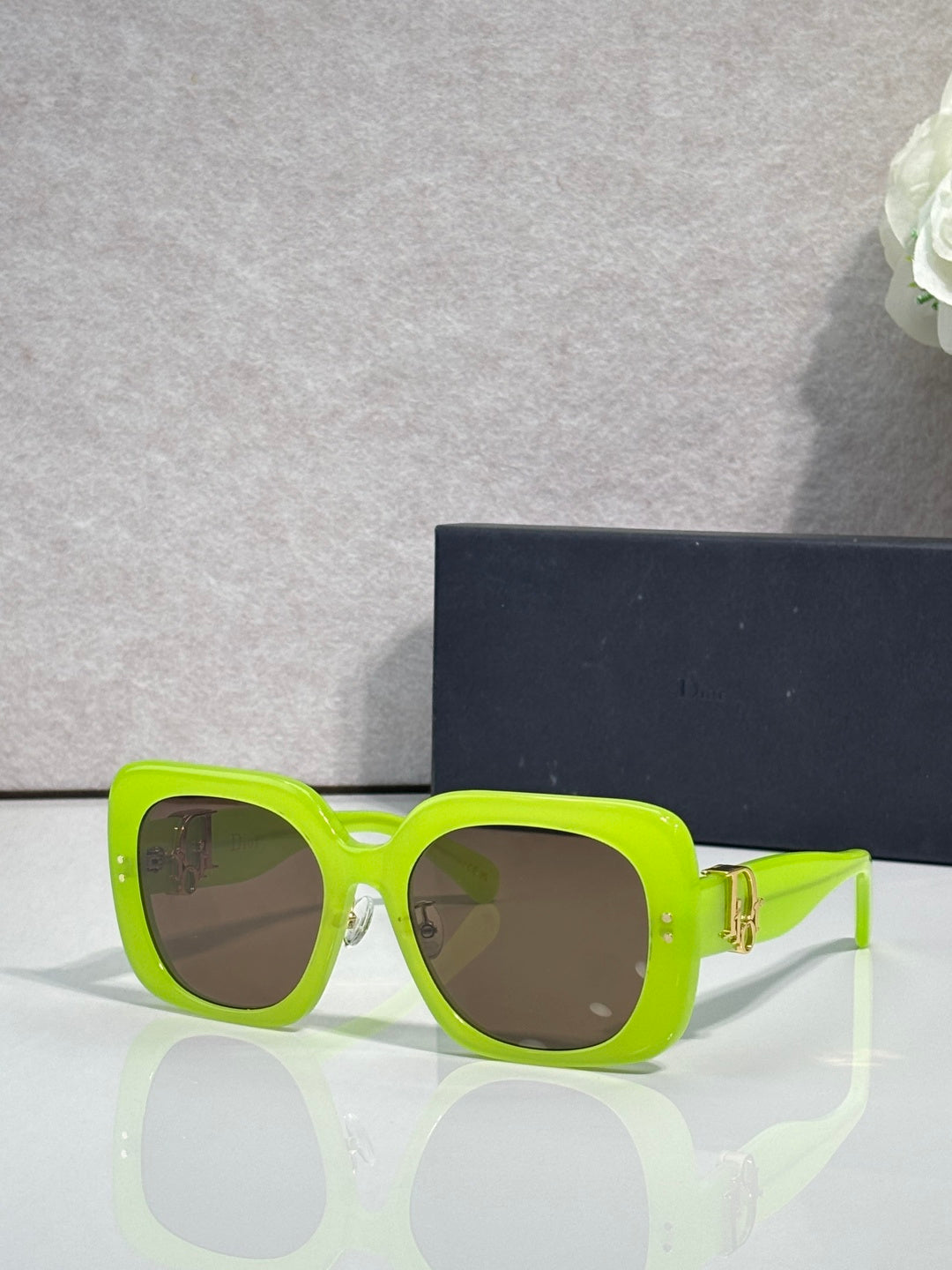 Neon green square sunglasses with dark lenses and gold logo hinge