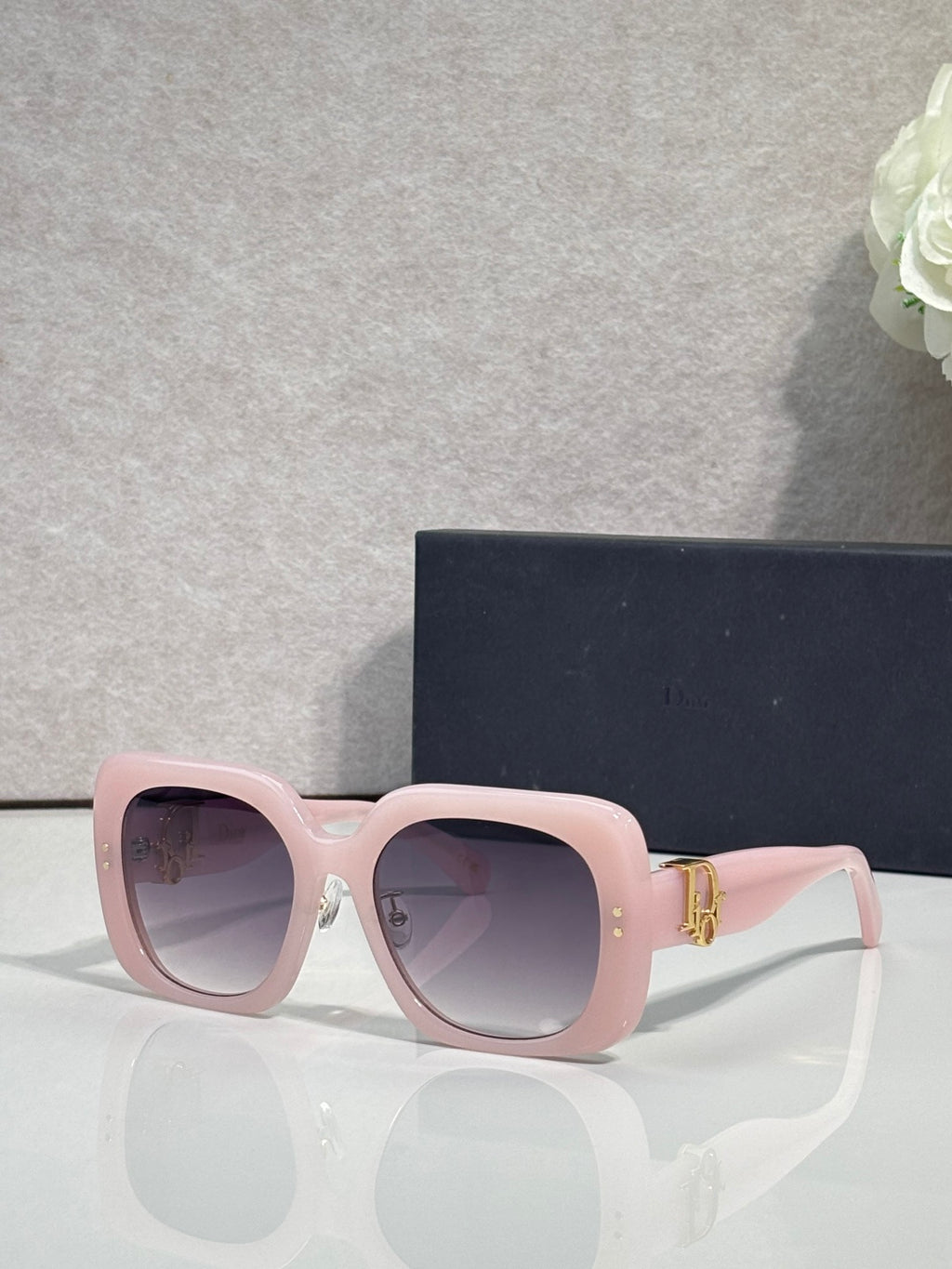 Pink square sunglasses with purple-tinted lenses and gold hinge details