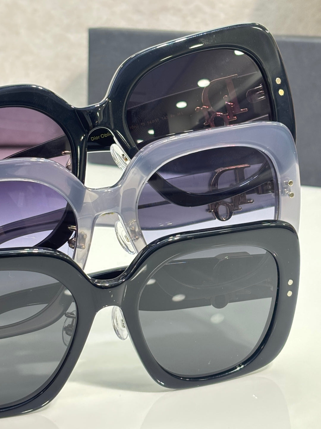Assorted square sunglasses with dark frames and tinted lenses, gold accents