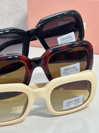 Assorted sunglasses frames in black, tortoise, and cream with logo lenses