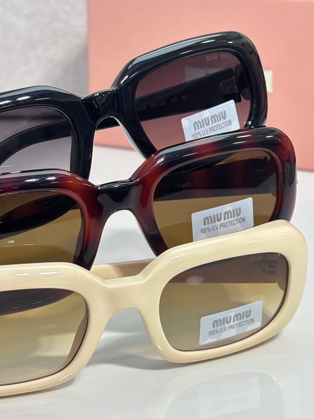 Assorted sunglasses frames in black, tortoise, and cream with logo lenses