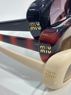 Close-up of glossy sunglasses frames in navy, burgundy, and cream tones