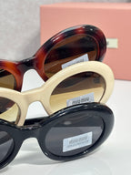 Overlapping round sunglasses with cream, tortoiseshell, and navy frames