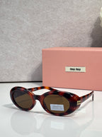 Round sunglasses with dark tortoiseshell frames and oval lenses