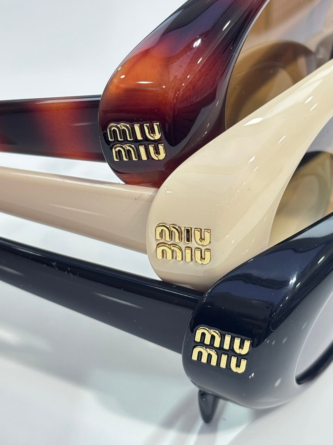 Sunglasses temples with miu miu logo in gold, cream and burgundy