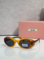 Round sunglasses with amber/gold frames and tapered temples