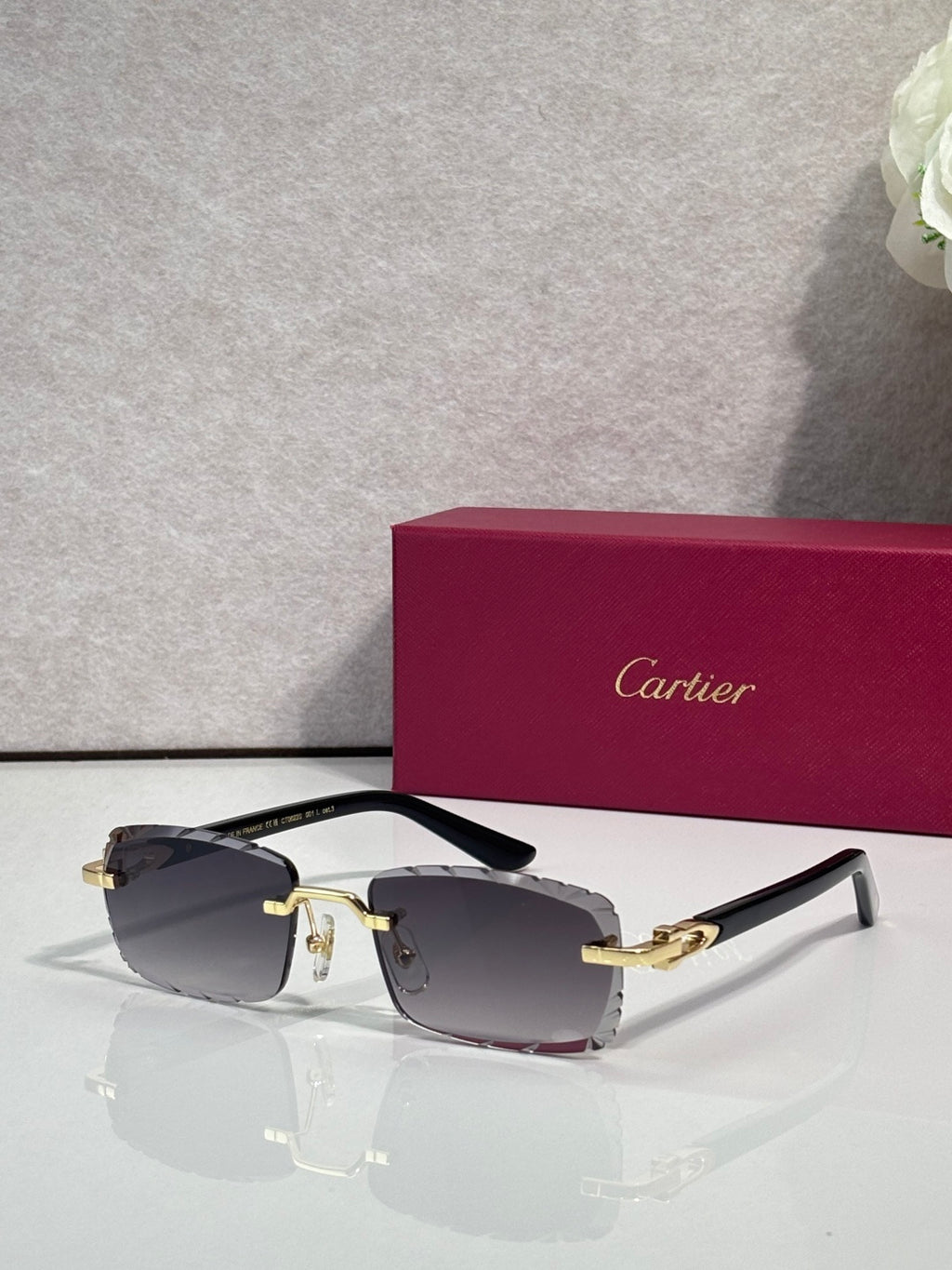 Cartier eyeglasses with dark gray lenses, silver frame, gold hinges, and black temple tips.
