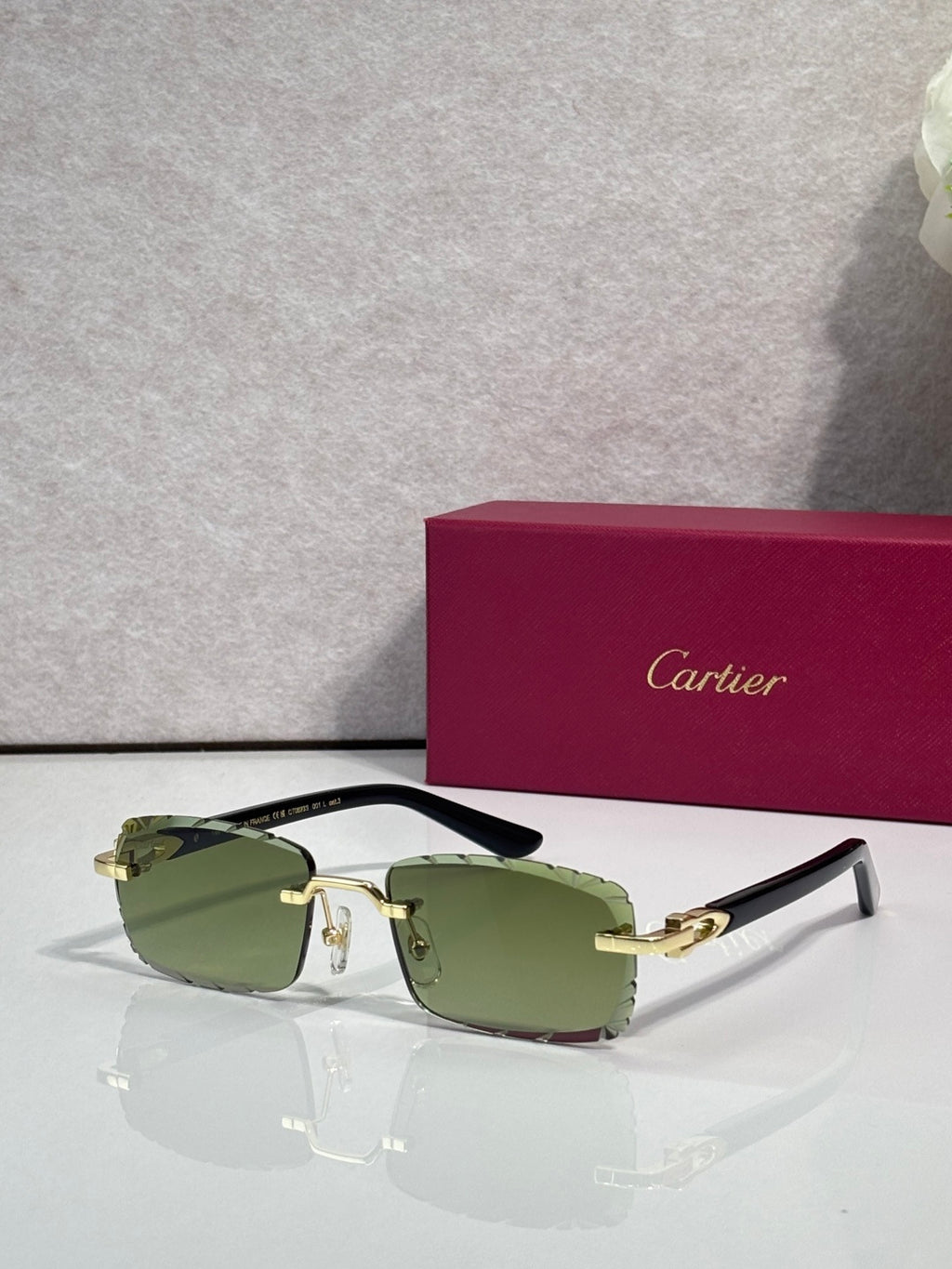 Cartier eyeglasses with green-tinted lenses, gold-toned metal frame, and black temple tips.