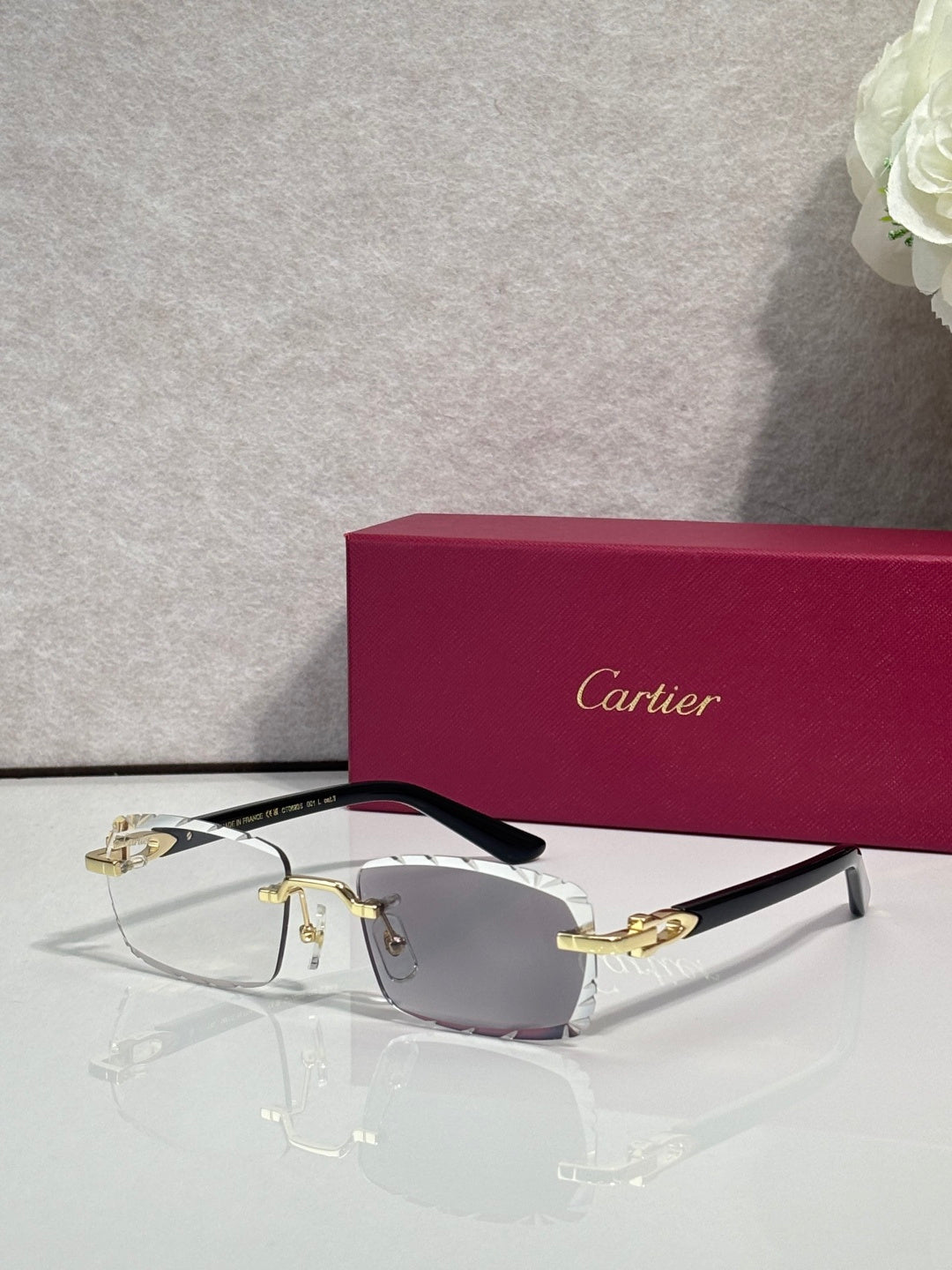 Cartier eyeglasses with gray lenses, silver metal frame, gold accents, and black temple tips.
