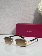 Cartier eyeglasses with brown-tinted lenses, gold metal frame, and black temple accents.