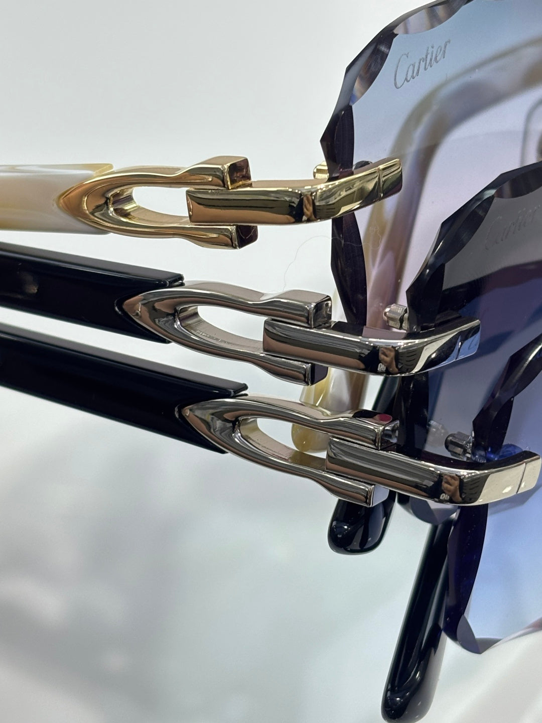 Cartier glasses close-up: black frame with gold hinges and metal logo