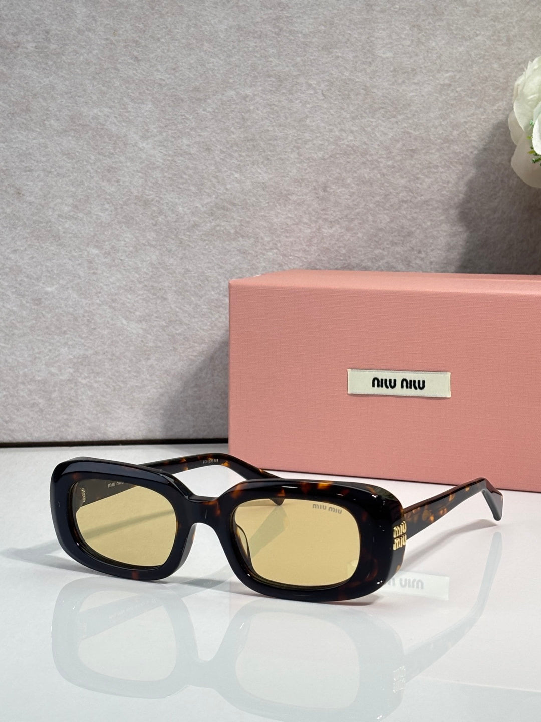Glasses with black frame and tortoiseshell accents, yellow-tinted rectangular lenses