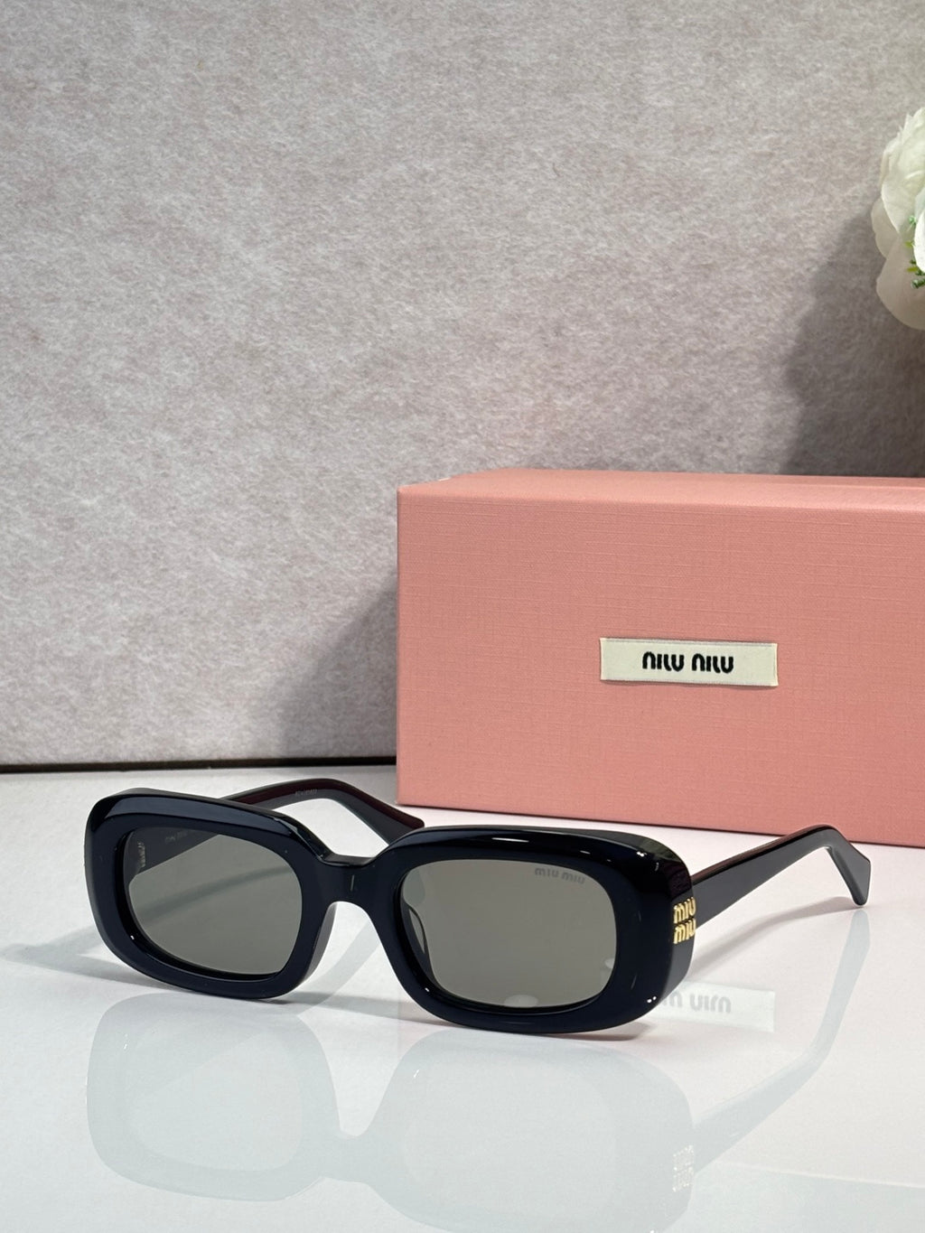 Glasses with black frame and dark tinted lenses, rounded rectangular face