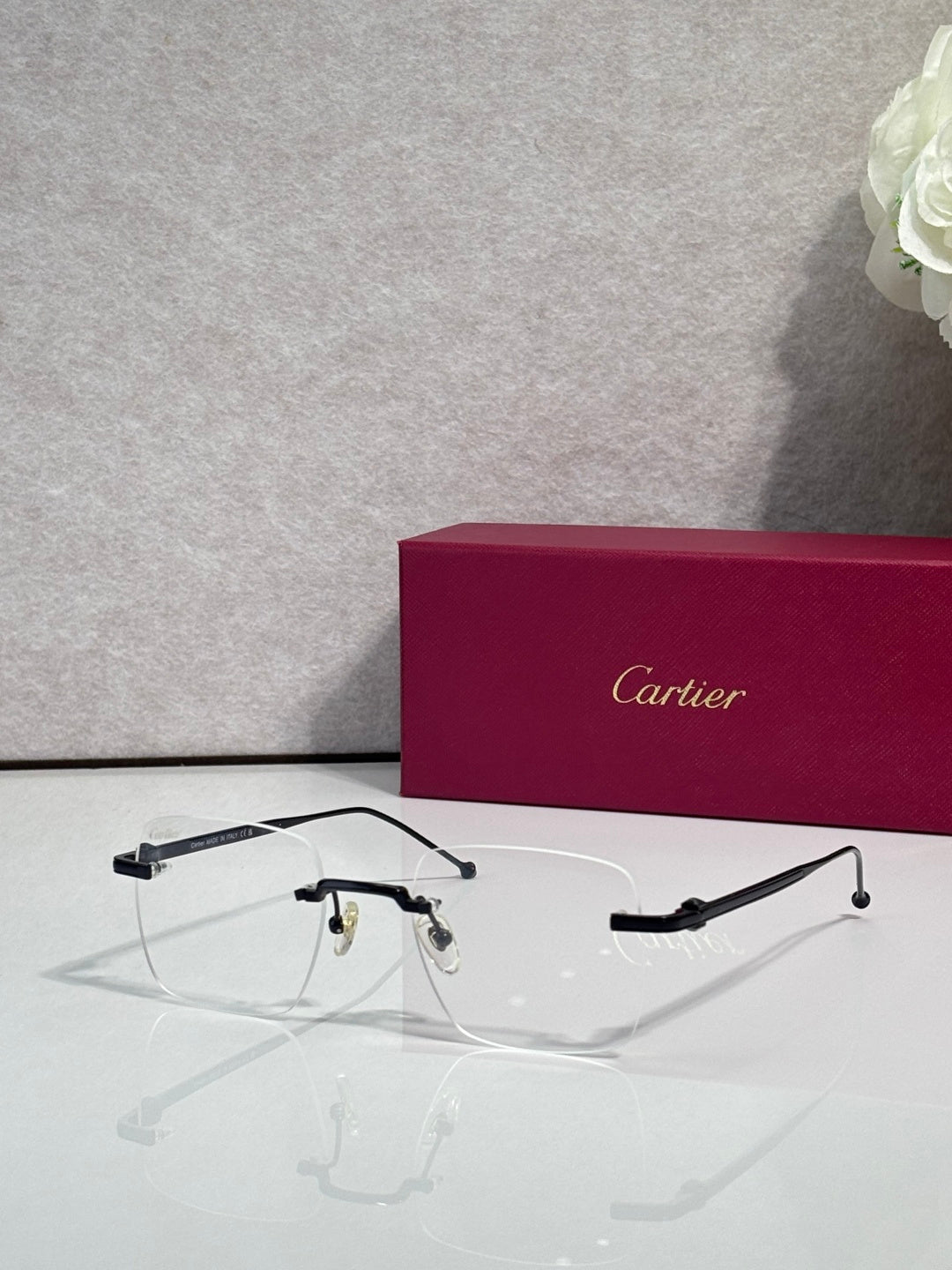 Dark metal eyeglasses with clear lenses, Cartier frame details.