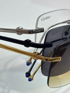 Close-up: metal eyeglasses hinges with blue accents, Cartier branding.