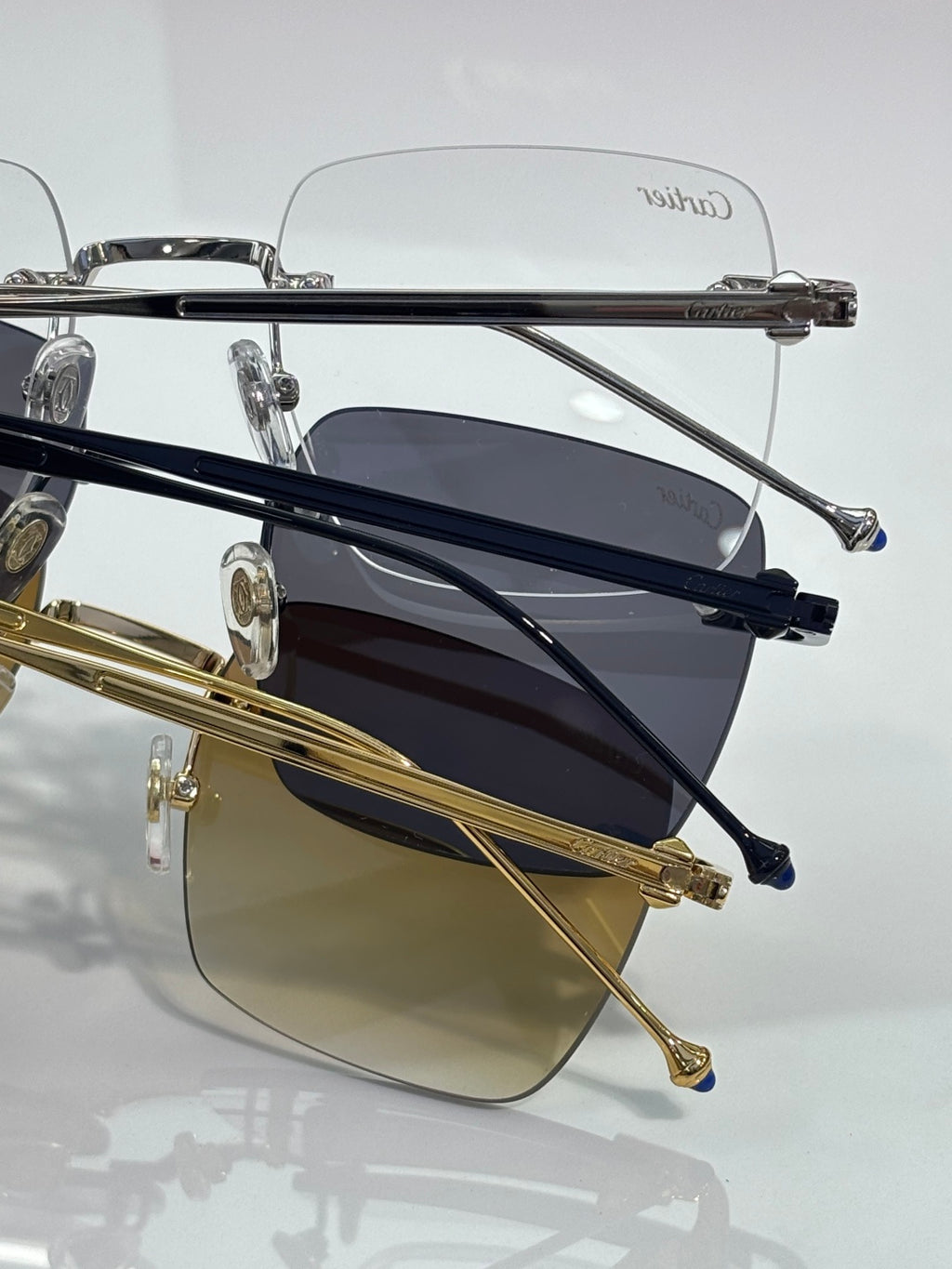 Side view of tinted sunglasses with gold and navy metal frames, Cartier.