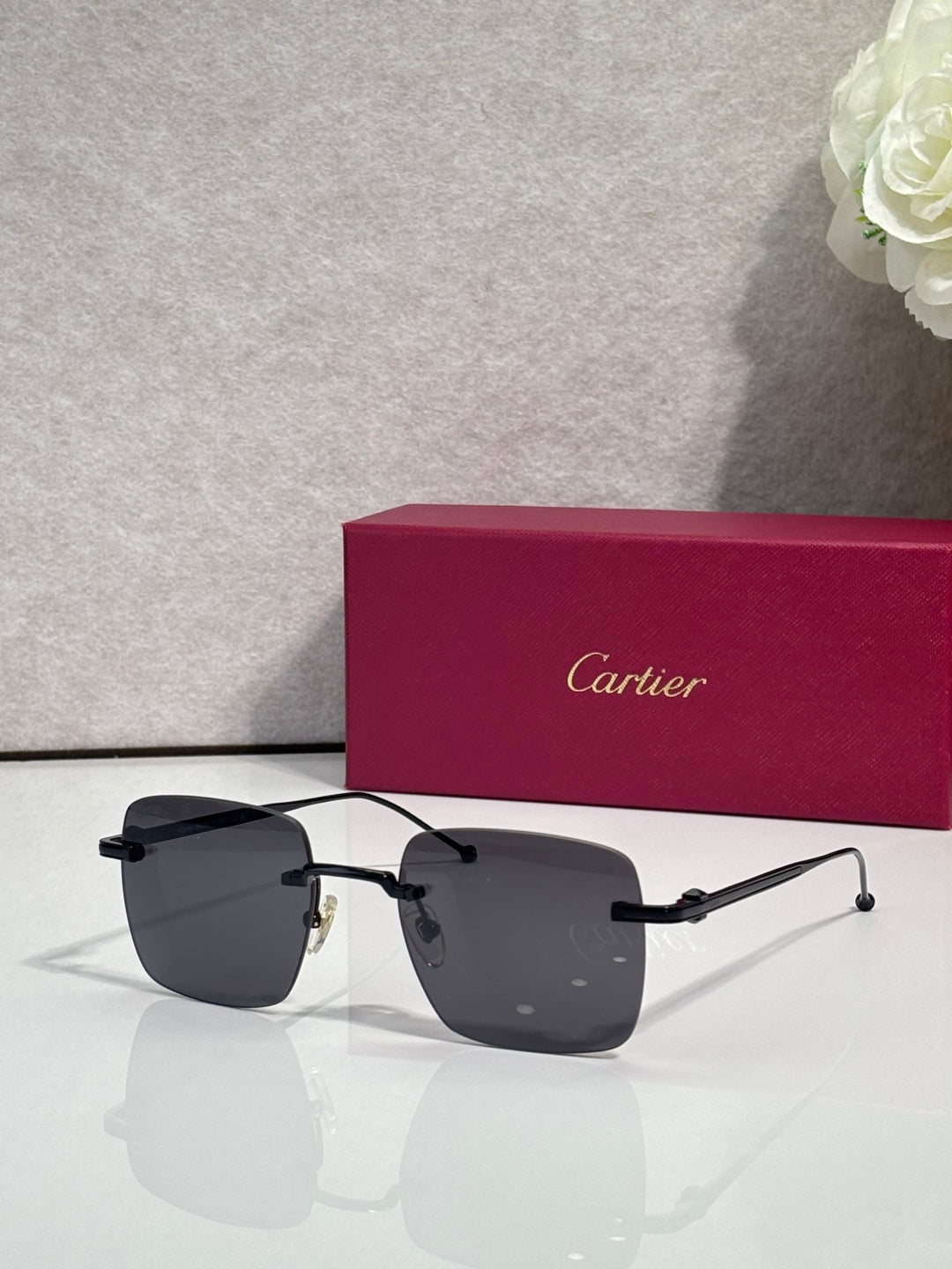 Dark sunglasses with black metal frame, Cartier temple details.