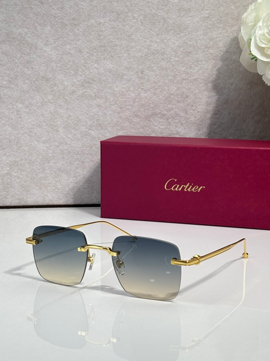 Cartier sunglasses with blue gradient lenses and gold frame, clear side arms.