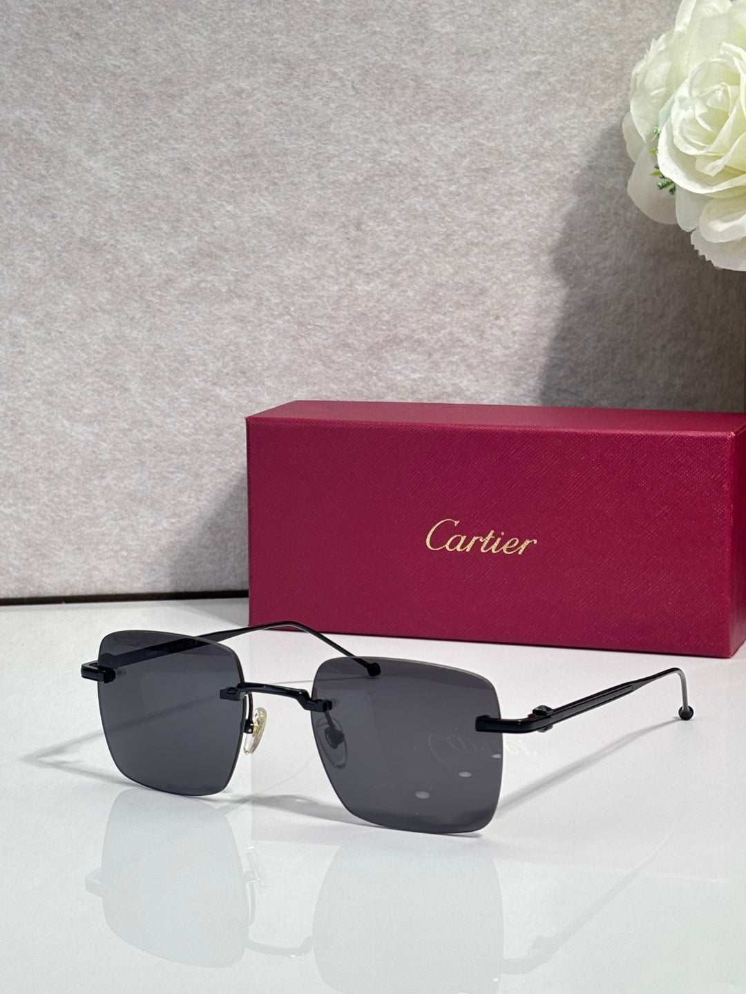 Cartier sunglasses with dark lenses and black frame accents, clear side arms.