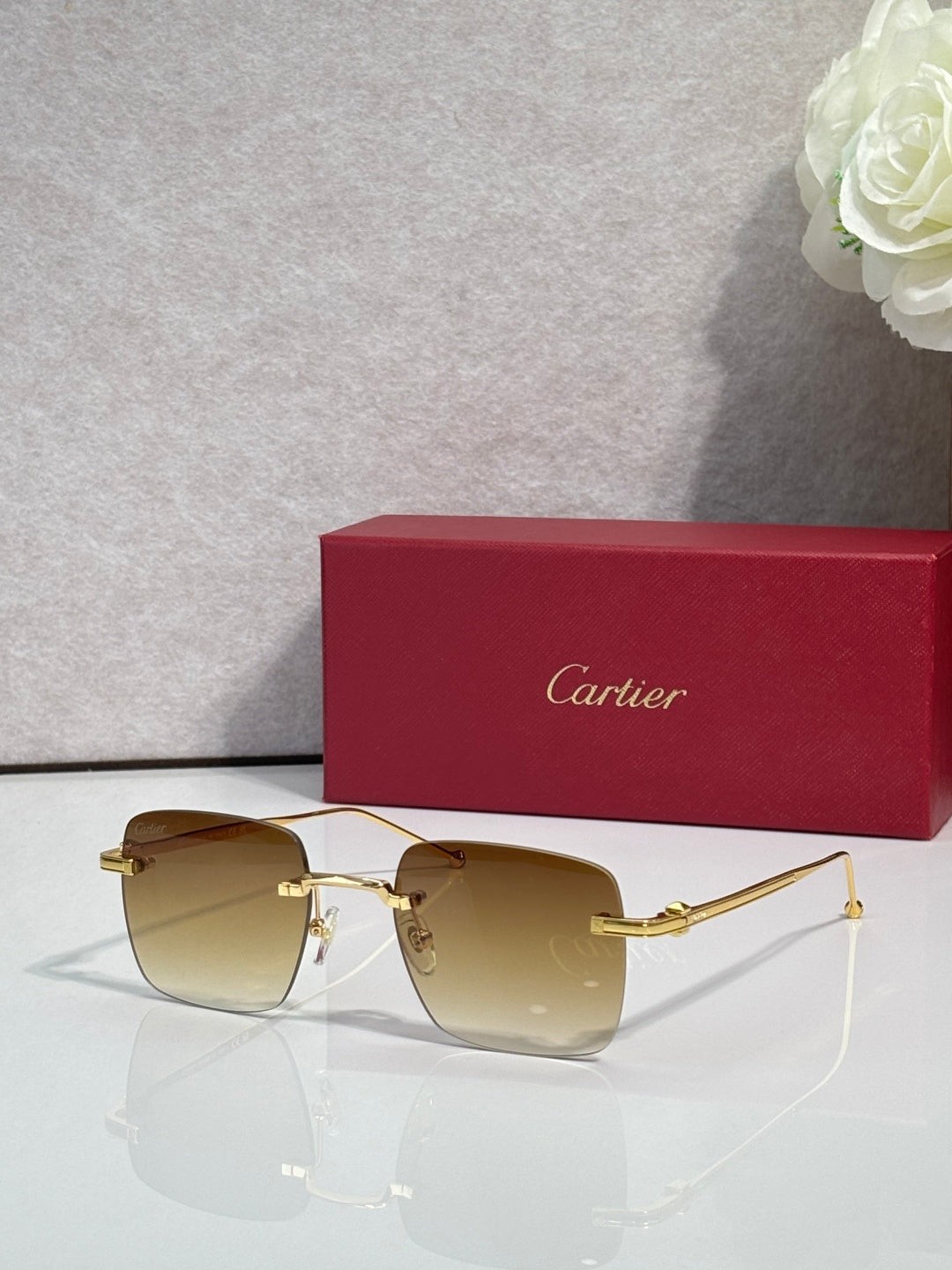 Cartier sunglasses with warm brown gradient lenses and gold frame, clear side arms.