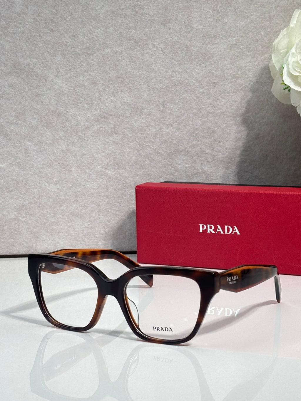 Prada tortoise eyeglasses with rectangular frames and black temples