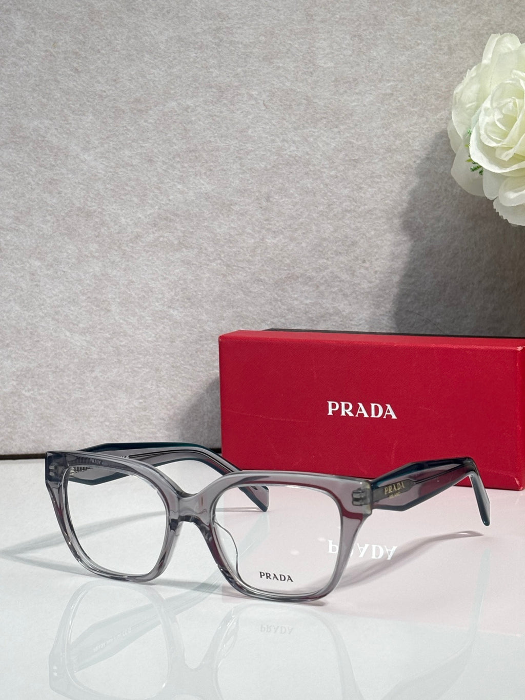 Prada gray eyeglasses with rectangular frames and clear-toned temples