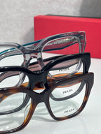 Prada eyeglass frames close-up with black, tortoise, and blue lenses