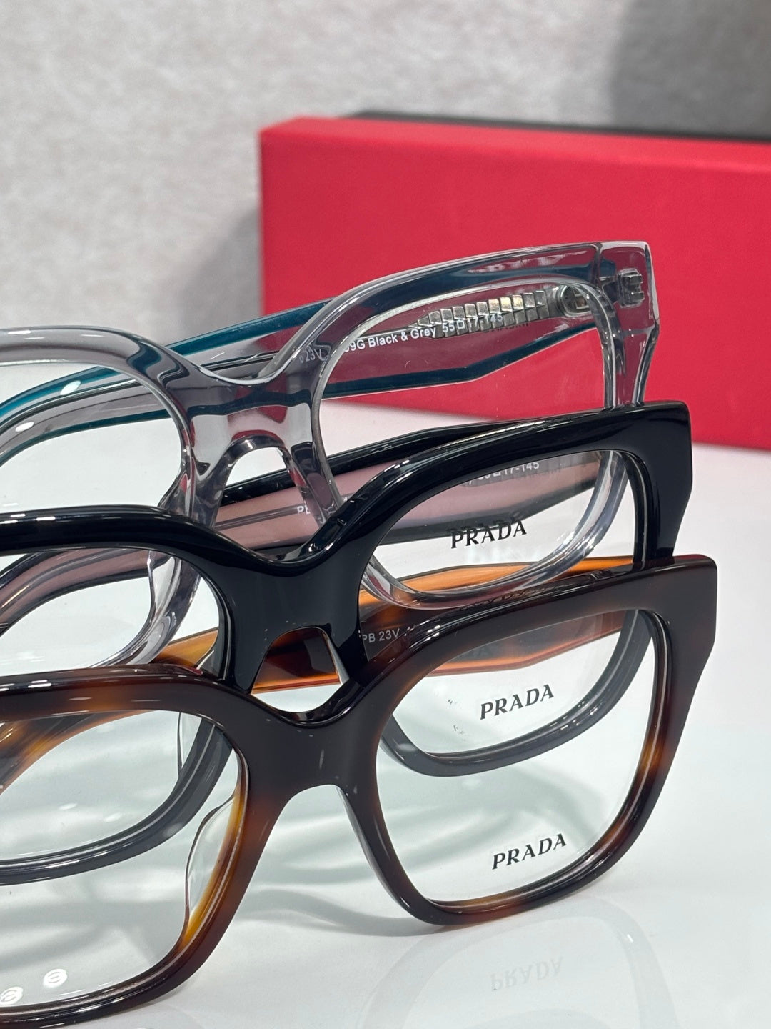 Prada eyeglass frames close-up with black, tortoise, and blue lenses