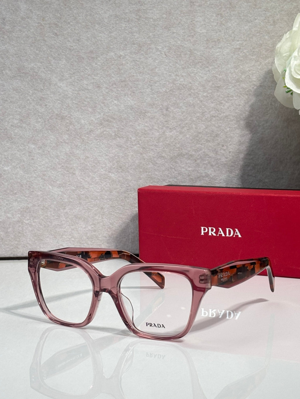 Prada burgundy eyeglasses with rectangular frames and patterned temples