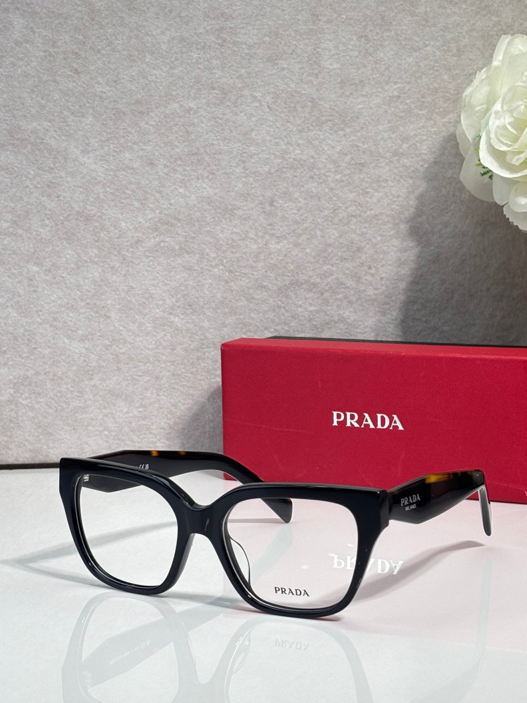 Prada black eyeglasses with rectangular frames and dark gray temples