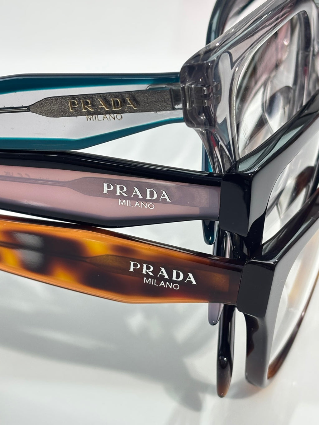 Prada eyeglass frames close-up with blue and black arms labeled MILANO