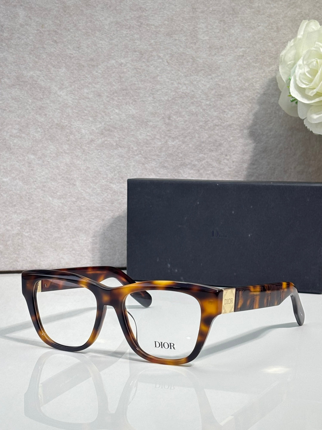 Tortoiseshell eyeglass frame with square lenses and gold temple accents
