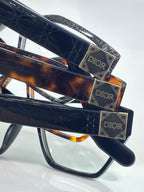 Dior eyeglasses, side close-up with gold Dior logo plaques and dark lenses