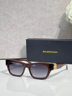 Balenciaga sunglasses with tortoiseshell-style frame, gold details, and dark tinted lenses