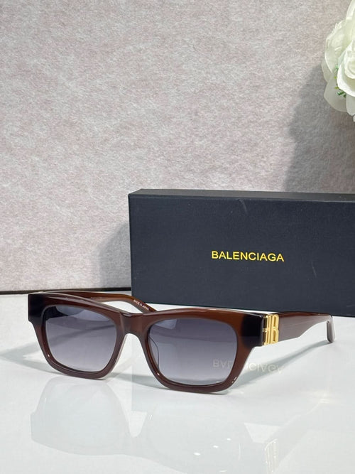 Balenciaga sunglasses with tortoiseshell-style frame, gold details, and dark tinted lenses