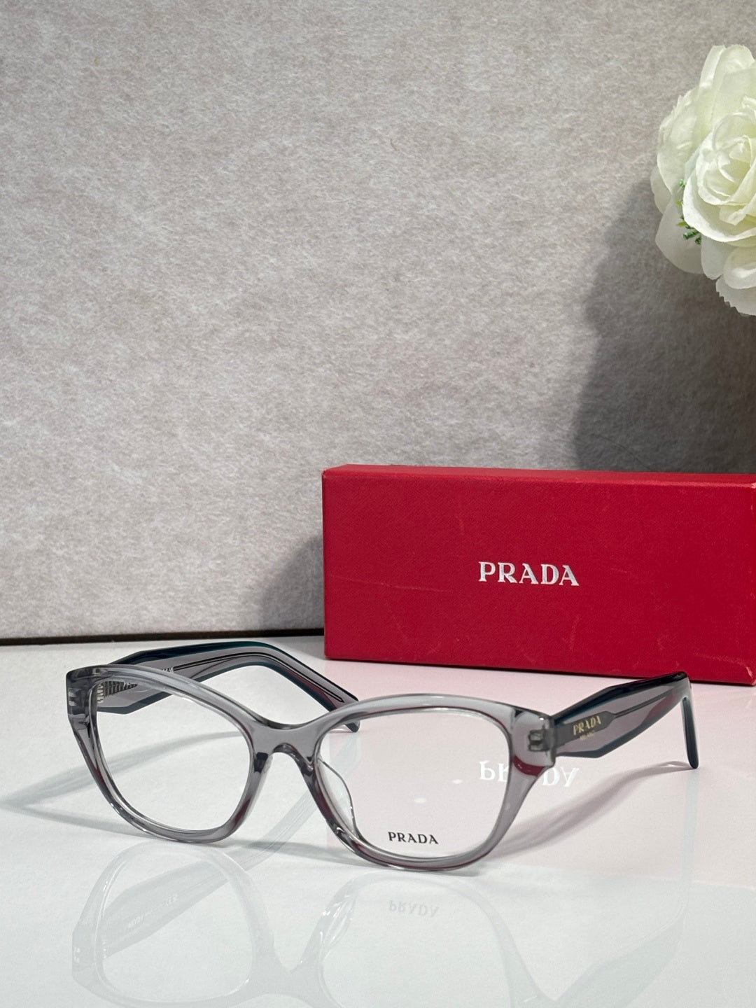 Silver gray Prada eyeglasses with rectangular frames and clear lenses