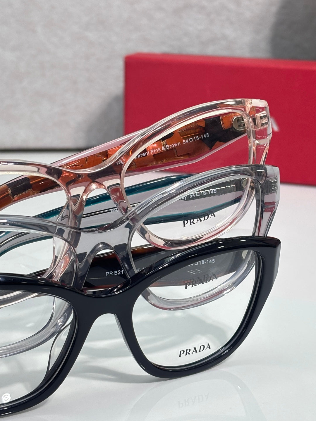 Prada eyeglasses close-up with layered frames in black and clear with logos