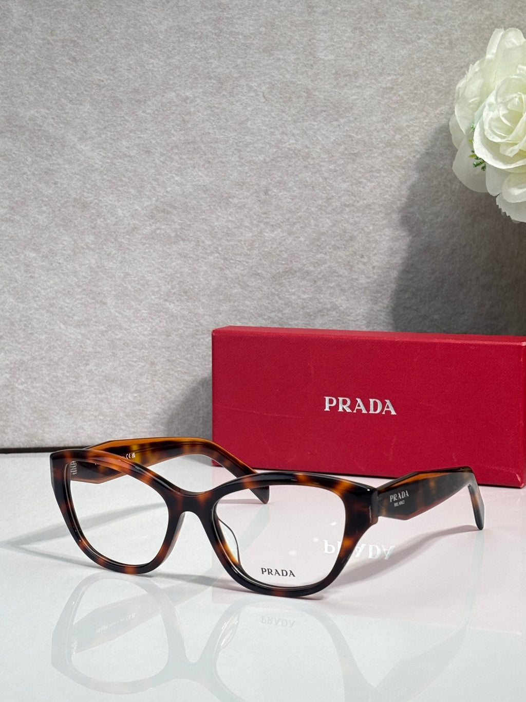 Tortoiseshell Prada eyeglasses with rectangular frames and clear lenses
