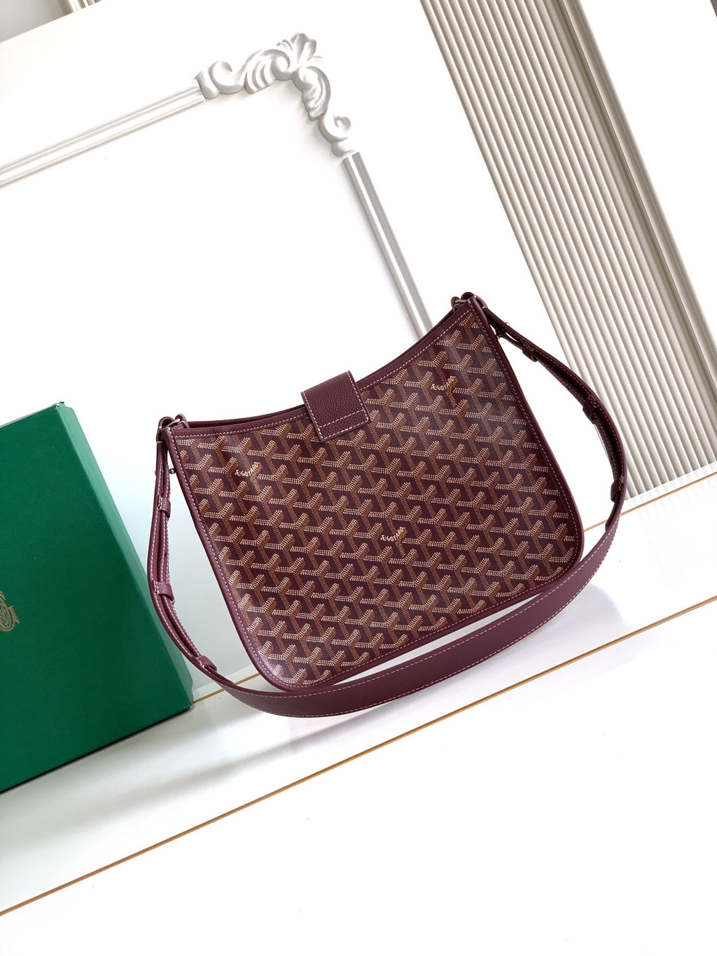 Maroon Goyard shoulder bag with textured monogram pattern and long strap