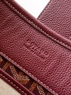 Maroon Goyard bag exterior with embossed logo and stitched edge seam detail