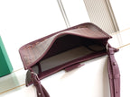 Open maroon Goyard shoulder bag showing interior lining and top zipper opening