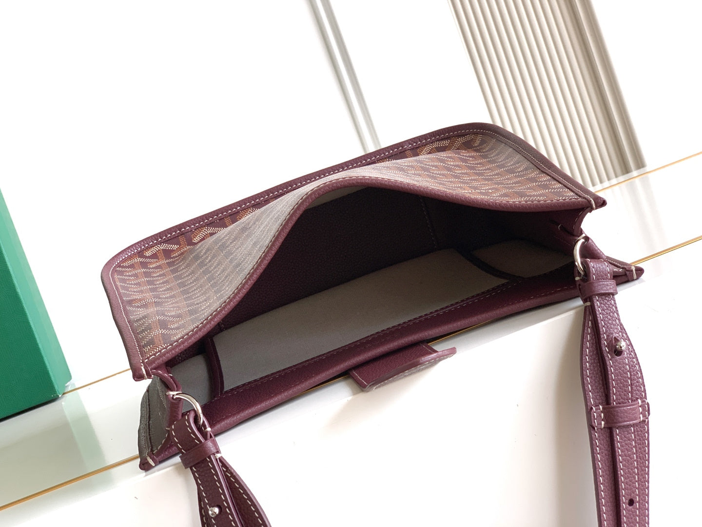 Open maroon Goyard shoulder bag showing interior lining and top zipper opening
