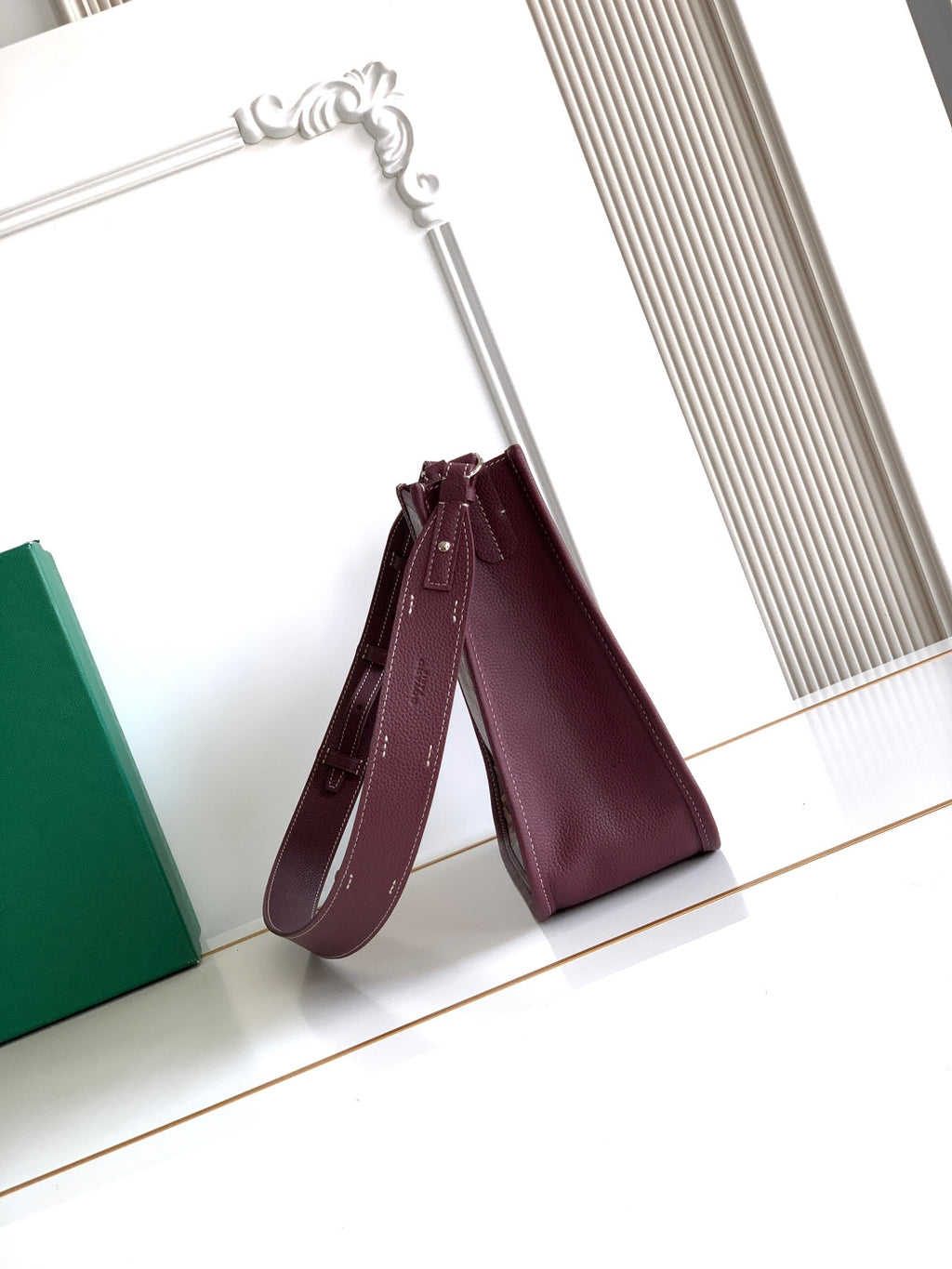 Maroon Goyard crossbody bag with short top handles and stitched logo detail