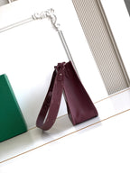 Maroon Goyard crossbody bag with short top handles and stitched logo detail